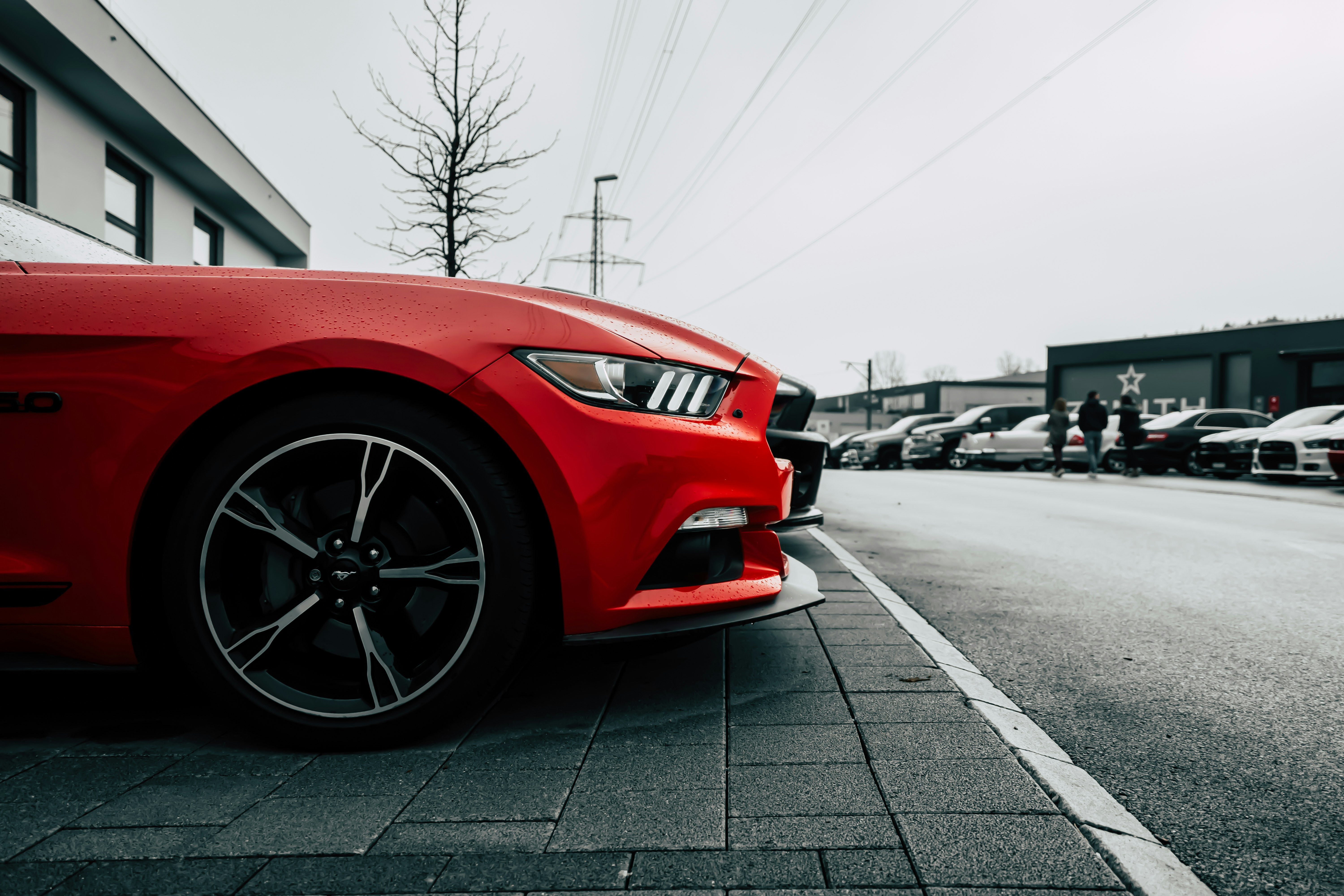 parked red Ford Mustang during daytime